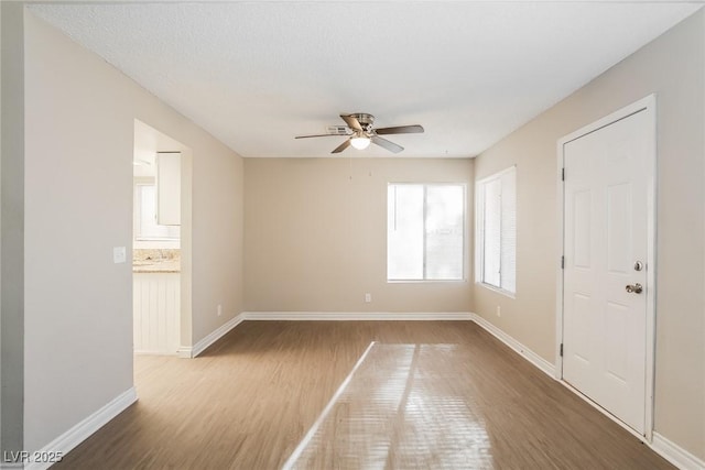 unfurnished room with hardwood / wood-style flooring, a textured ceiling, and ceiling fan