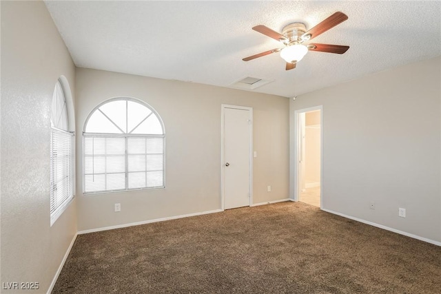 empty room featuring carpet floors, a wealth of natural light, a textured ceiling, and ceiling fan