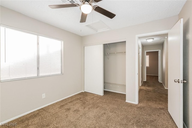 unfurnished bedroom with ceiling fan, a closet, a textured ceiling, and carpet flooring