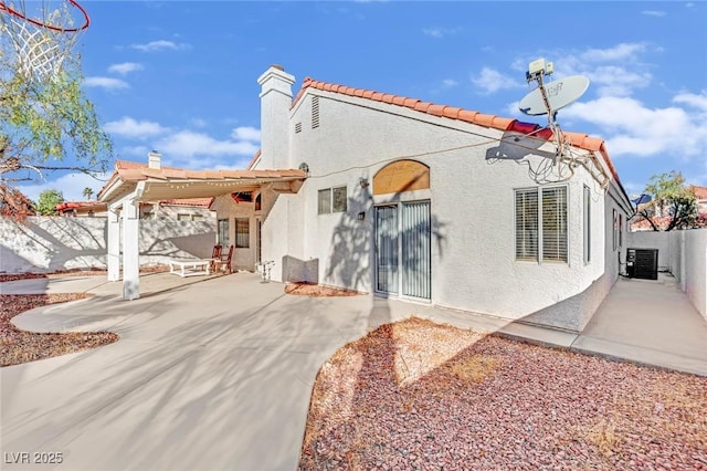 rear view of property featuring central AC unit, a pergola, and a patio