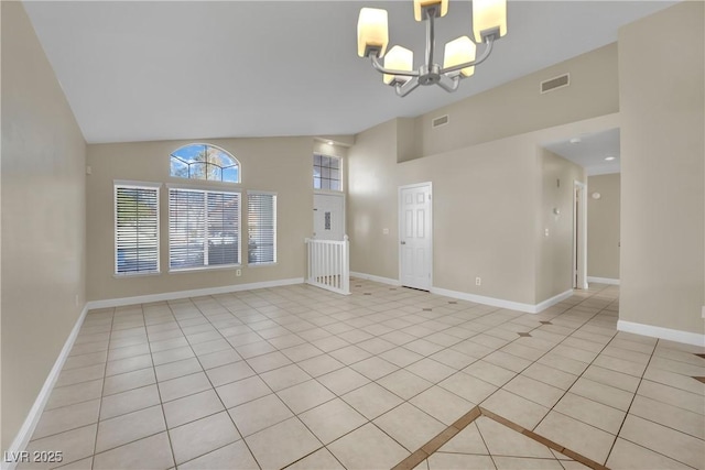 spare room featuring lofted ceiling, light tile patterned flooring, and a chandelier