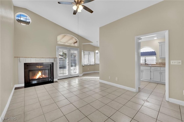 unfurnished living room with vaulted ceiling, ceiling fan, light tile patterned floors, and french doors