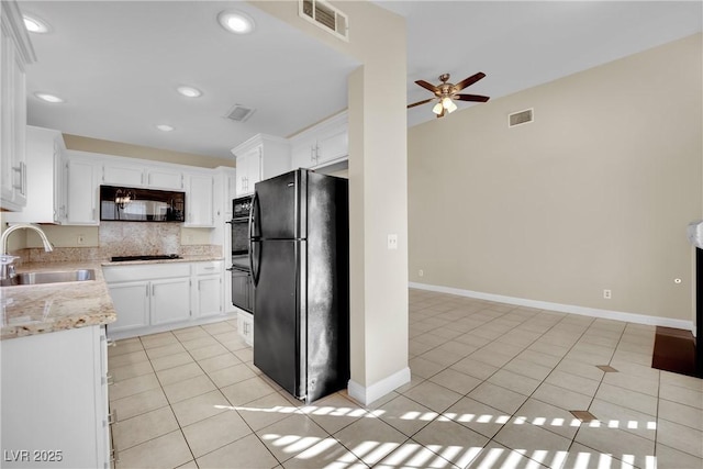 kitchen featuring black appliances, white cabinets, sink, and light tile patterned floors