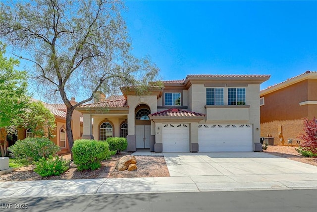 mediterranean / spanish-style house featuring a garage and central AC