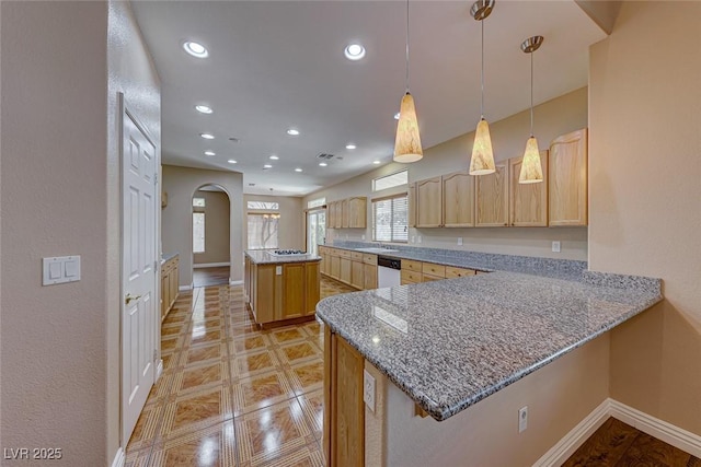 kitchen featuring light stone countertops, decorative light fixtures, light brown cabinets, kitchen peninsula, and stainless steel dishwasher