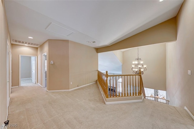 spare room with carpet and a notable chandelier