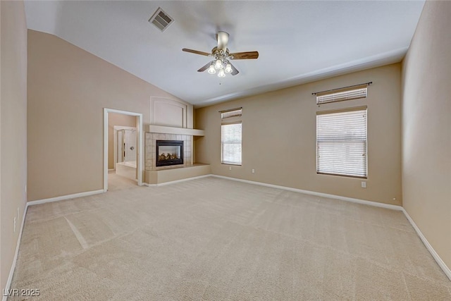 unfurnished living room with ceiling fan, light colored carpet, a tile fireplace, and lofted ceiling