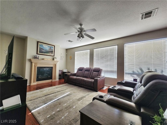 living room featuring a textured ceiling, ceiling fan, and hardwood / wood-style floors