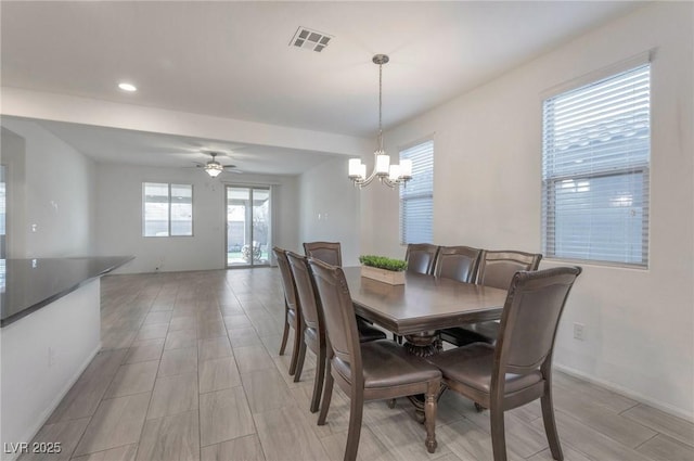 dining room featuring ceiling fan with notable chandelier