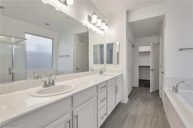 bathroom featuring vanity, wood-type flooring, and independent shower and bath