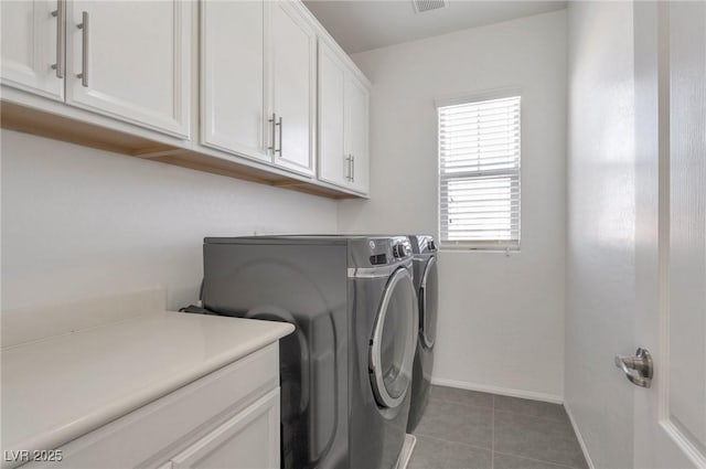 laundry room with washer and dryer, cabinets, and tile patterned floors