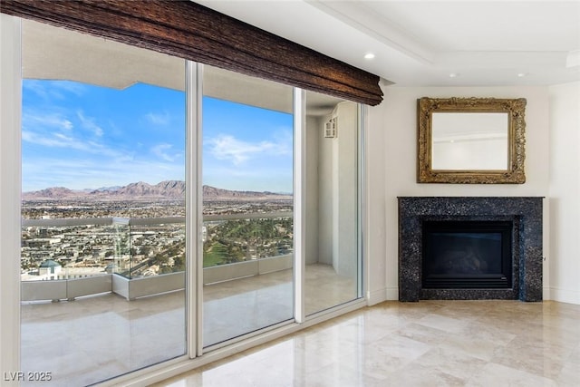 doorway to outside with expansive windows, a premium fireplace, and a mountain view