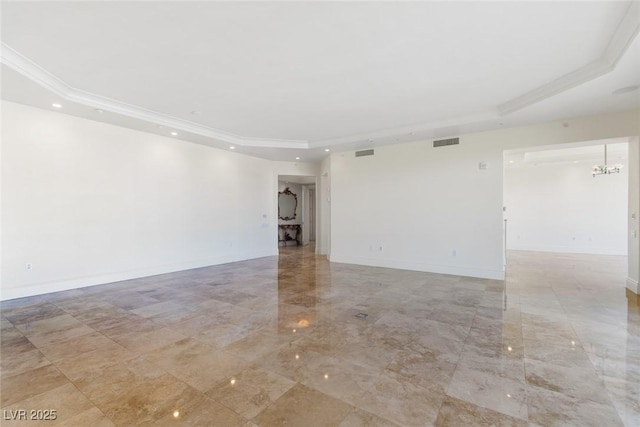 spare room with crown molding and a raised ceiling