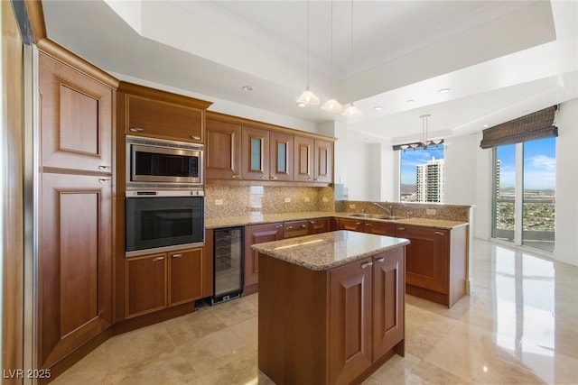 kitchen featuring pendant lighting, appliances with stainless steel finishes, a center island, wine cooler, and a tray ceiling