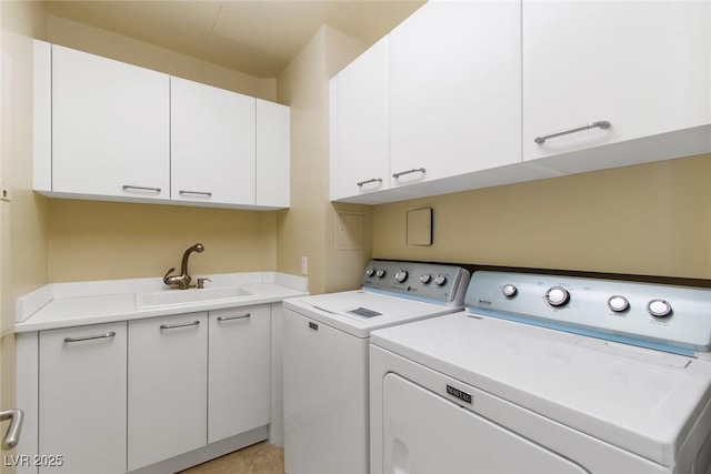 laundry room featuring cabinets, independent washer and dryer, and sink