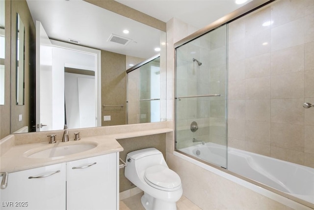 full bathroom with toilet, vanity, and shower / bath combination with glass door