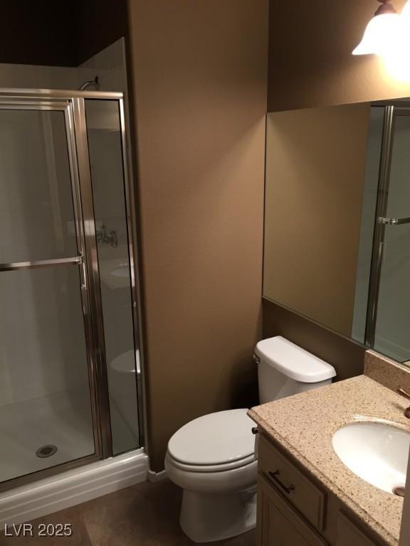 bathroom with toilet, tile patterned flooring, a shower with door, and vanity