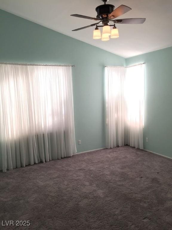 carpeted spare room featuring ceiling fan and vaulted ceiling