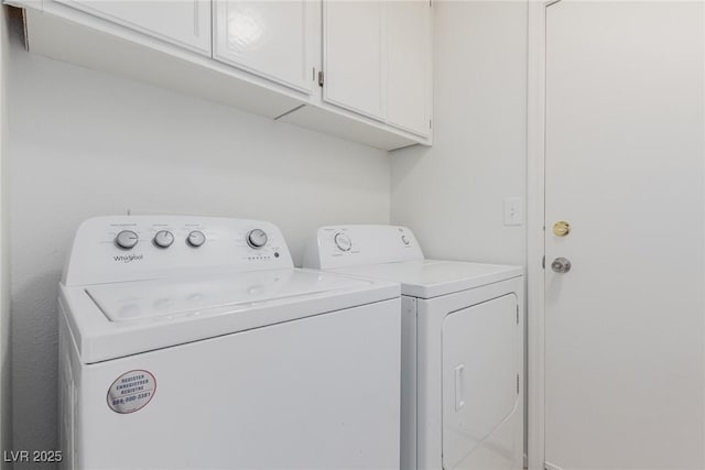 washroom with cabinets and washer and clothes dryer