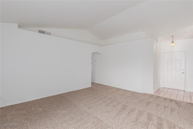 empty room featuring light colored carpet and vaulted ceiling