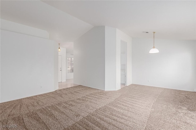 spare room with light carpet and vaulted ceiling