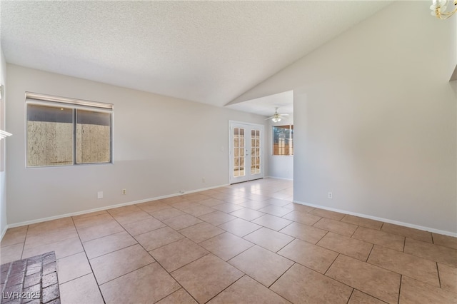 spare room featuring lofted ceiling, a healthy amount of sunlight, light tile patterned floors, and ceiling fan