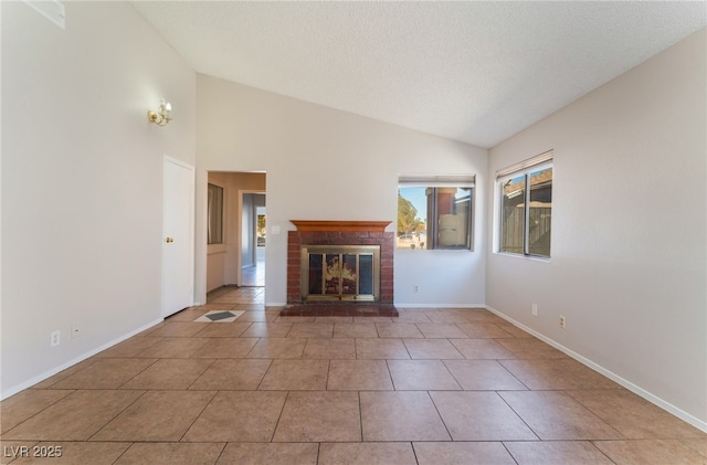 unfurnished living room with light tile patterned floors, vaulted ceiling, and a brick fireplace