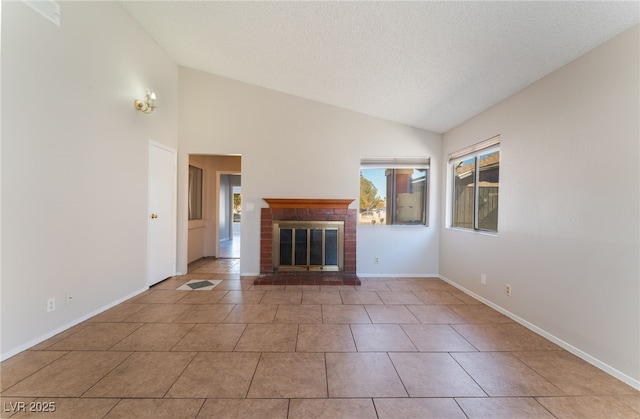 unfurnished living room featuring a fireplace, light tile patterned floors, vaulted ceiling, and a textured ceiling