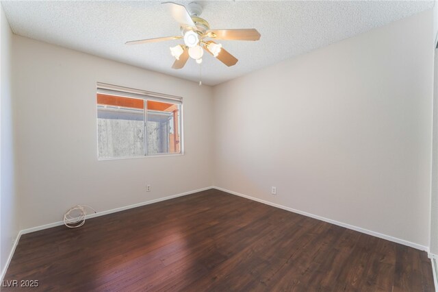 empty room featuring ceiling fan, dark wood-type flooring, and a textured ceiling