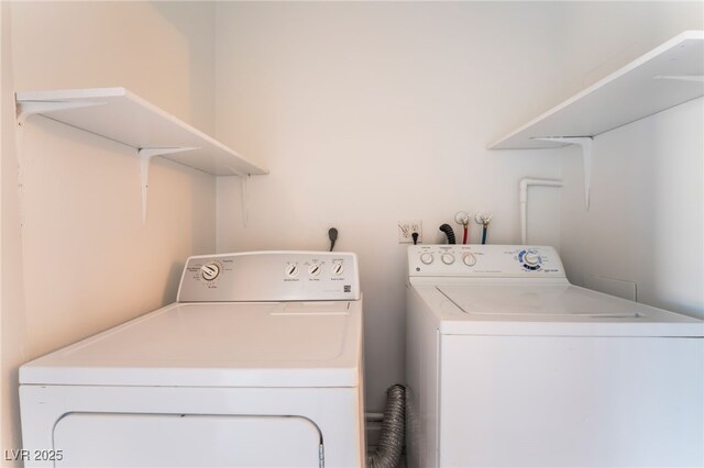 clothes washing area with washer and clothes dryer