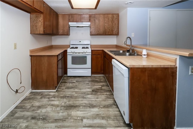 3790 Desert Marina Dr Unit 147, Laughlin, NV 89029 - kitchen with white appliances, under cabinet range hood, a sink, light countertops, and brown cabinetry