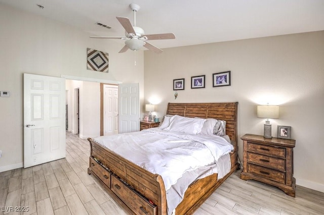 bedroom featuring ceiling fan, light hardwood / wood-style flooring, and lofted ceiling