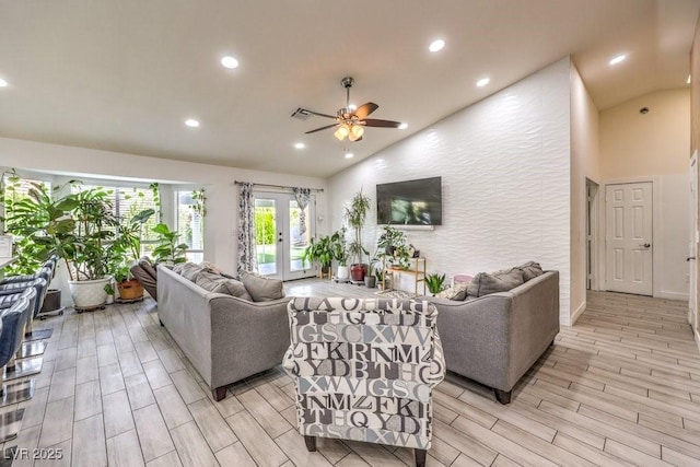 living room with ceiling fan, french doors, and high vaulted ceiling