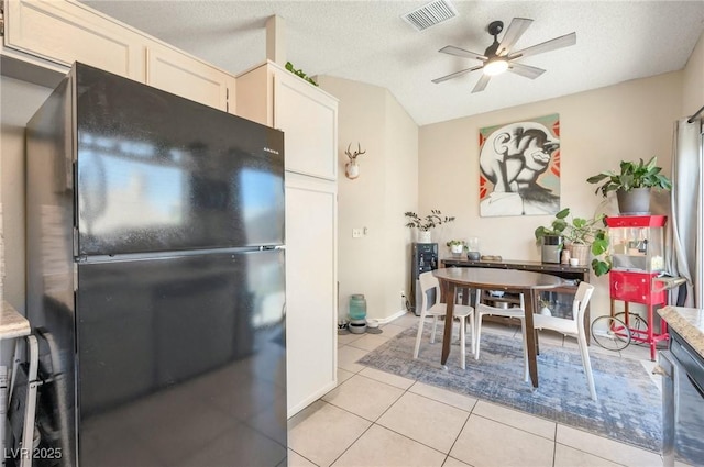 tiled dining space featuring ceiling fan and a textured ceiling