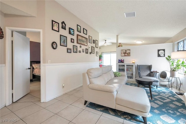 tiled living room featuring lofted ceiling and a textured ceiling