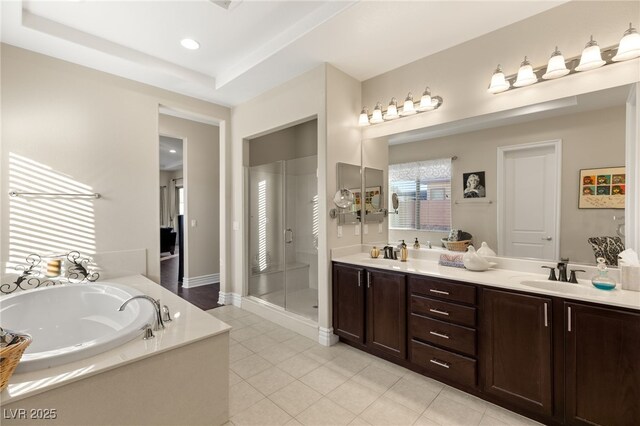 bathroom with tile patterned floors, a raised ceiling, independent shower and bath, and vanity