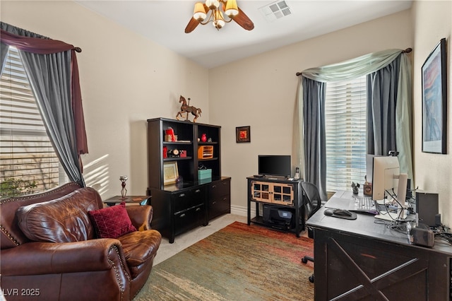 carpeted office space featuring ceiling fan