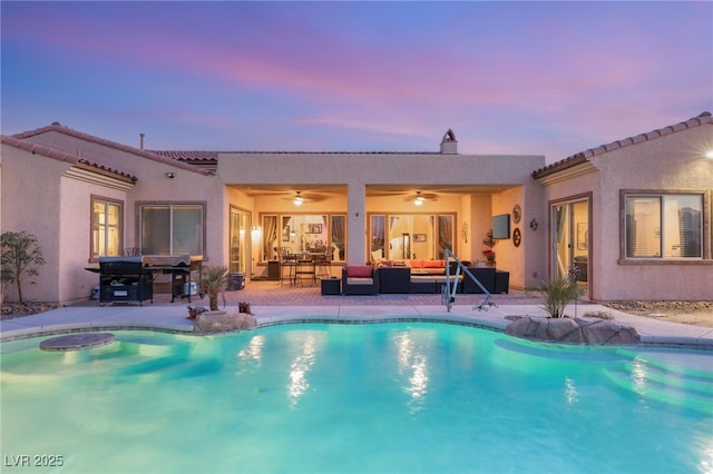 pool at dusk with an outdoor living space, a patio, and ceiling fan