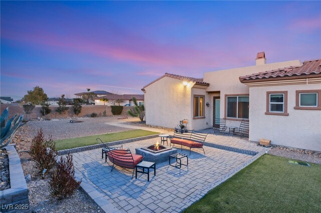 patio terrace at dusk featuring a fire pit