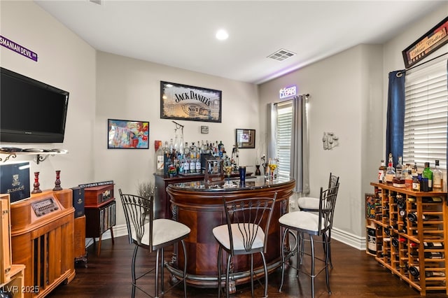 bar with dark hardwood / wood-style flooring