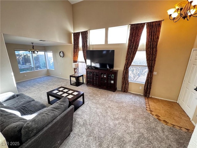 carpeted living room with an inviting chandelier, plenty of natural light, and a high ceiling