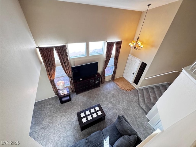 living room featuring a chandelier, carpet, and a high ceiling