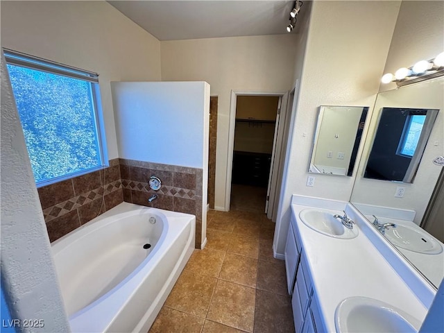 bathroom with a bathing tub, tile patterned floors, and vanity