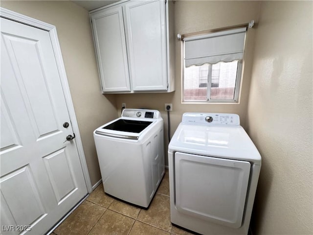 washroom with independent washer and dryer, light tile patterned floors, and cabinets