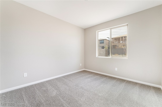 carpeted empty room featuring baseboards