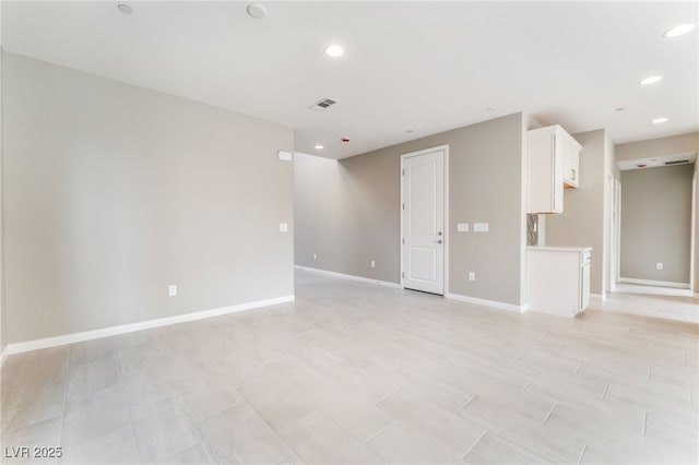 empty room featuring visible vents, recessed lighting, and baseboards