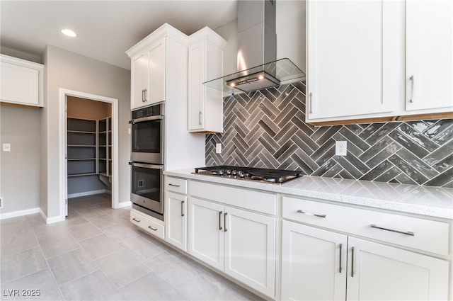 kitchen with light stone counters, stainless steel appliances, white cabinets, wall chimney exhaust hood, and backsplash