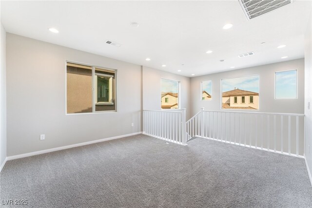 carpeted spare room featuring recessed lighting, visible vents, and baseboards