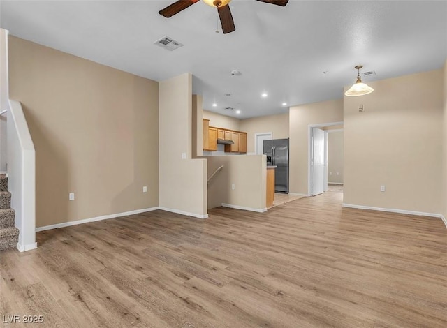 unfurnished living room with recessed lighting, visible vents, light wood-style flooring, baseboards, and stairs