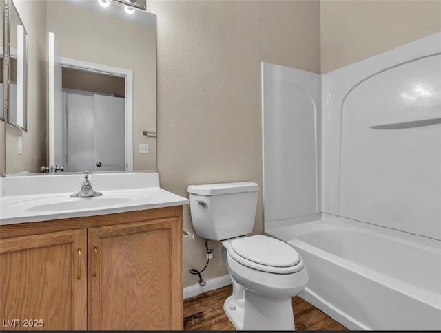 full bathroom with baseboards, toilet, shower / tub combination, wood finished floors, and vanity